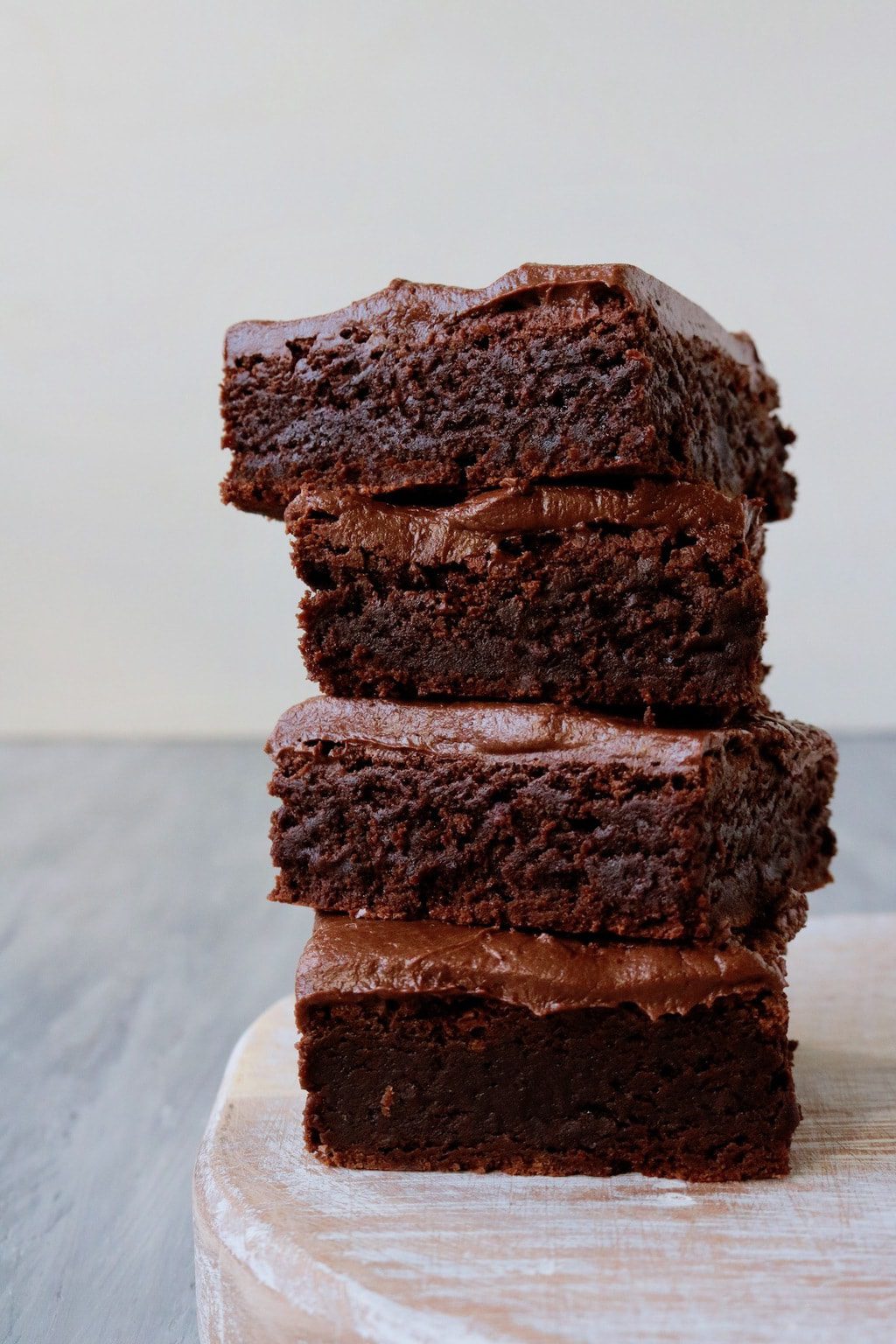 four frosted brownies stacked on top of each other