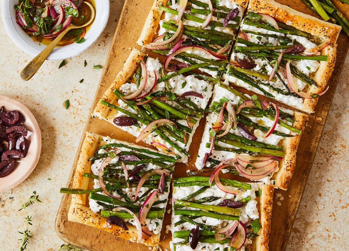 cottage cheese and asparagus puff pastry tart on a board