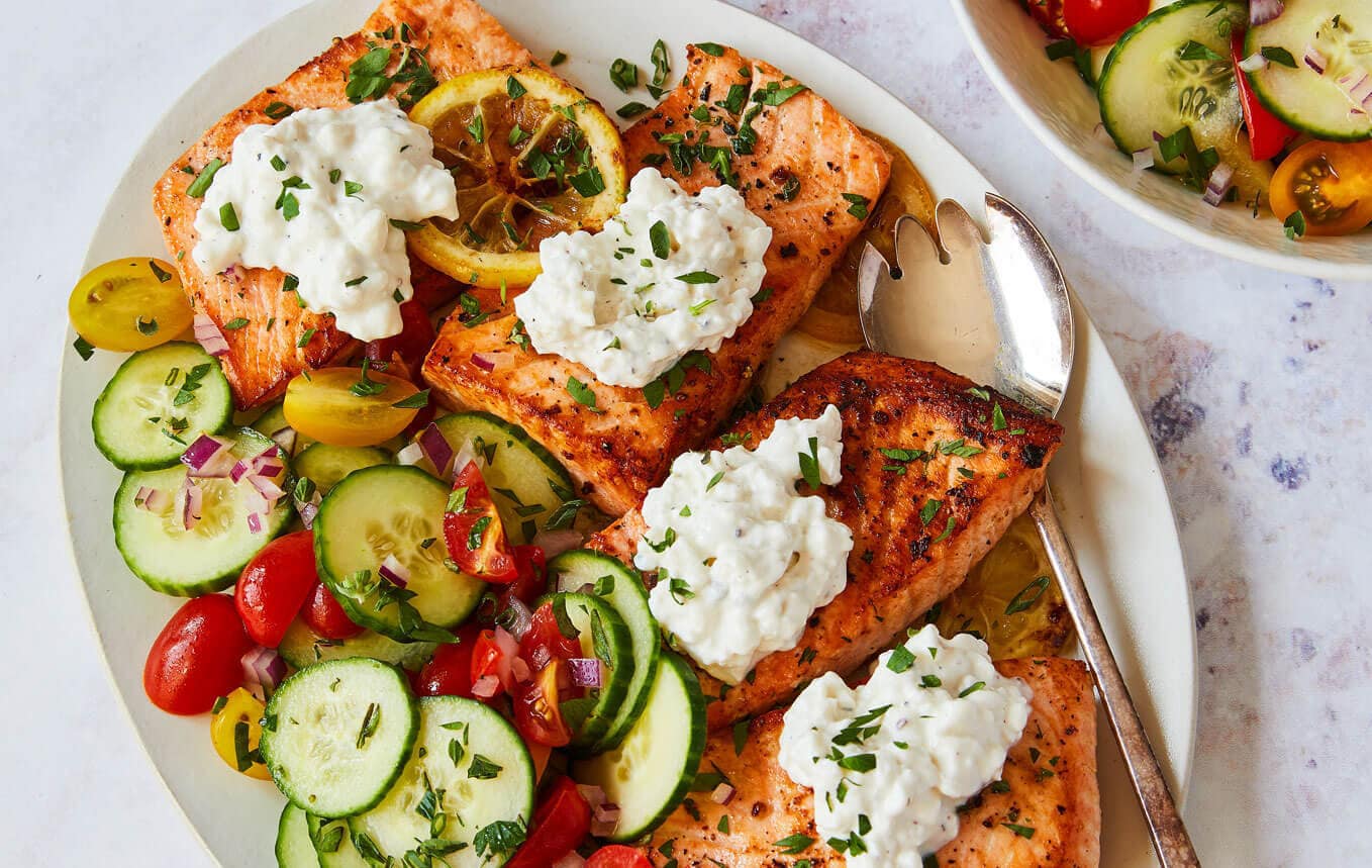 close up of lemon butter salmon with cottage cheese on a platter