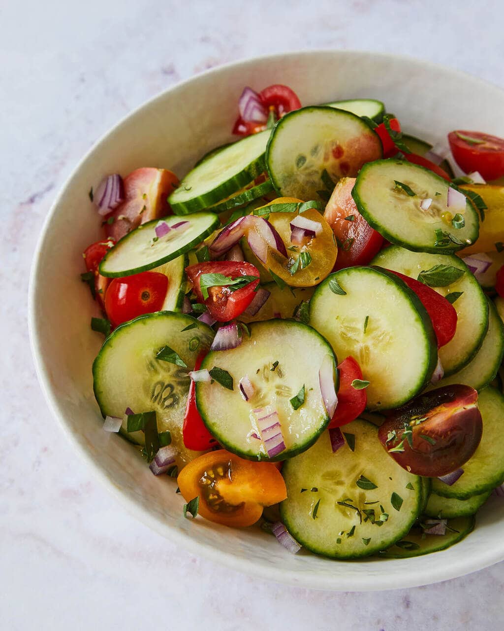 cucumber and tomato salad with lemon, herbs and red onion