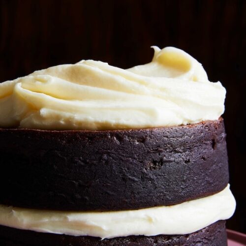 White cream cheese frosting on dark chocolate cake