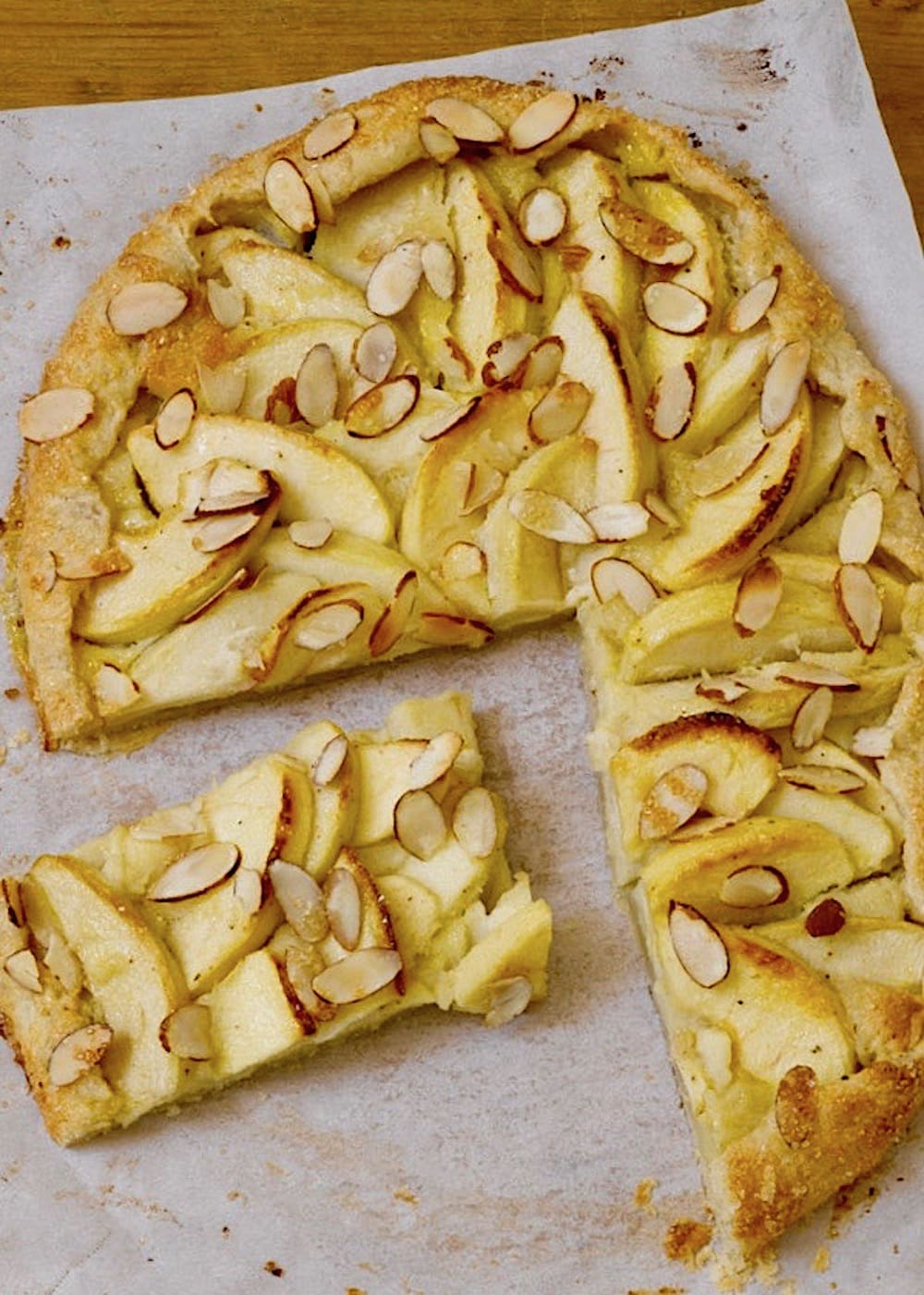 apple tart with sliced almonds on parchment