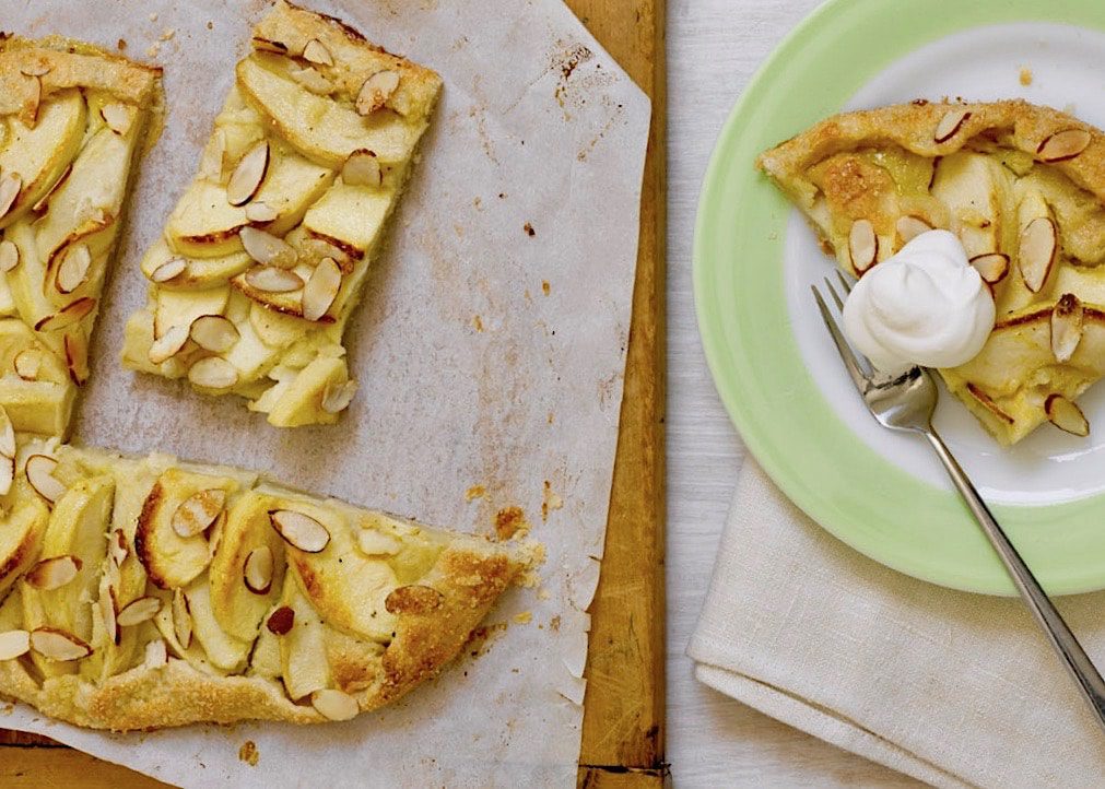 apple tart on a green plate with whipped cream