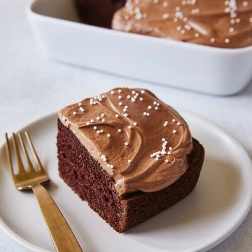 Piece of chocolate cake on a white plate with Extra Rich Milk Chocolate Frosting