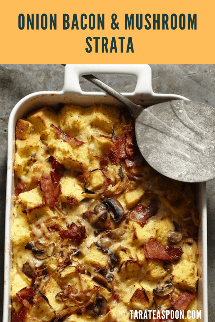 Onion Bacon Mushroom Strata in white baking dish with serving spoon