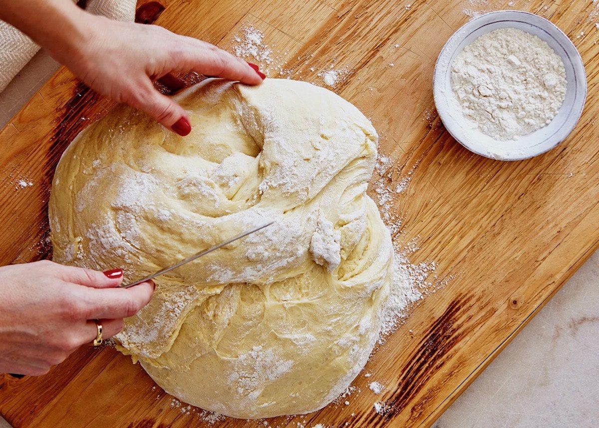 Cortando la masa del pan de cardamomo en una tabla