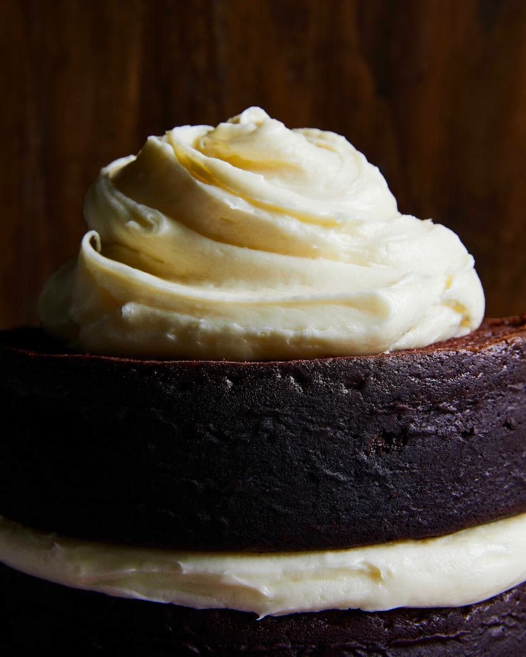 White cream cheese frosting on top of dark chocolate cake rounds