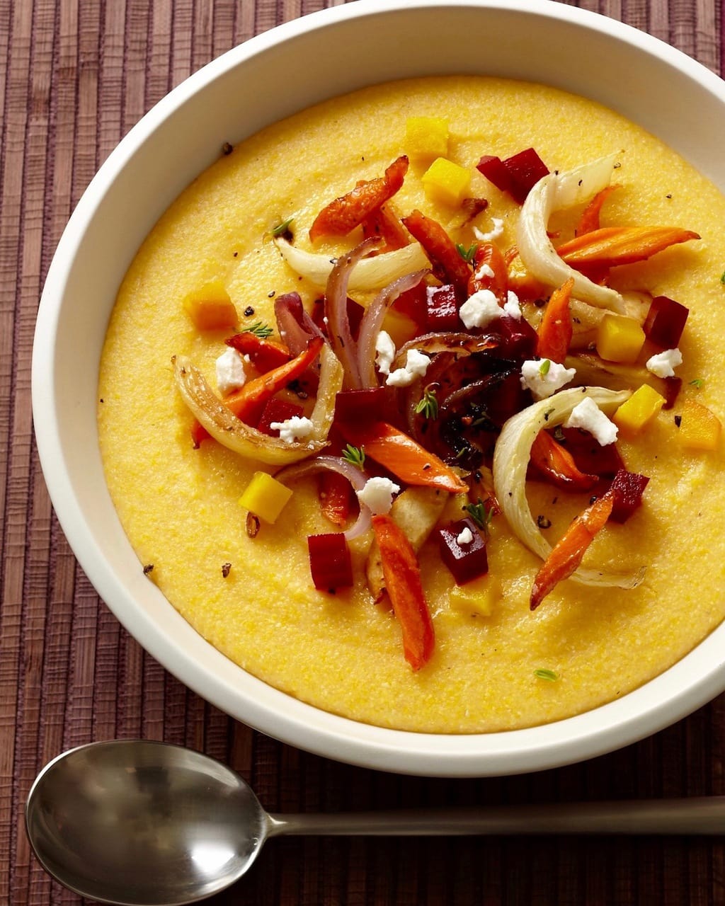 Creamy polenta recipe in a bowl topped with roasted vegetables