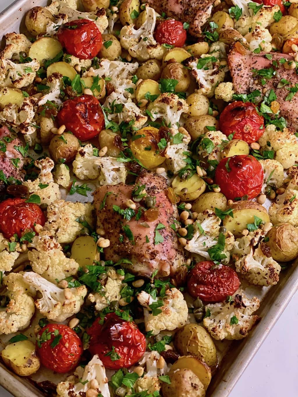 chicken and cauliflower sheet pan dinner with potatoes and tomatoes