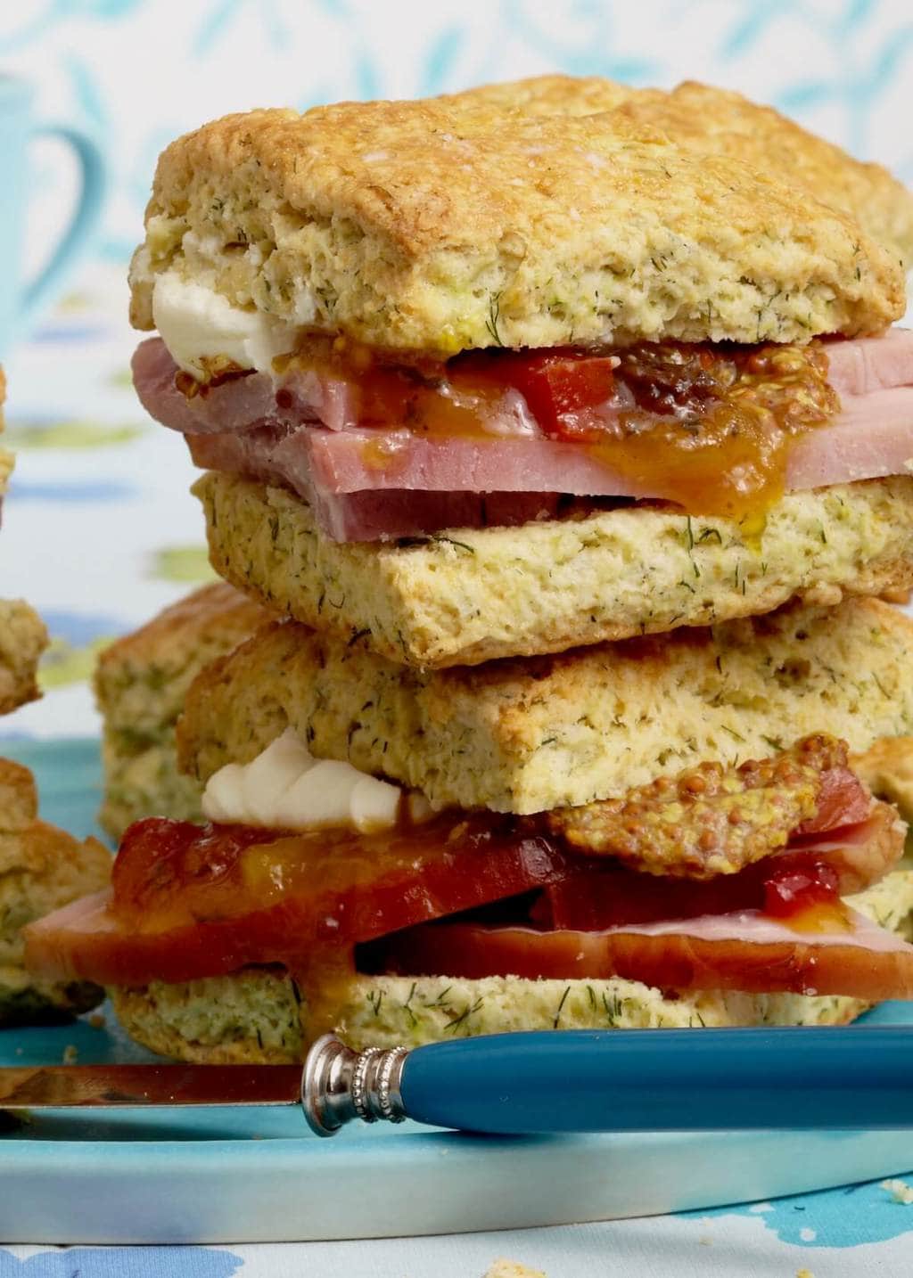 biscuits with ham and dill on blue plate with a knife