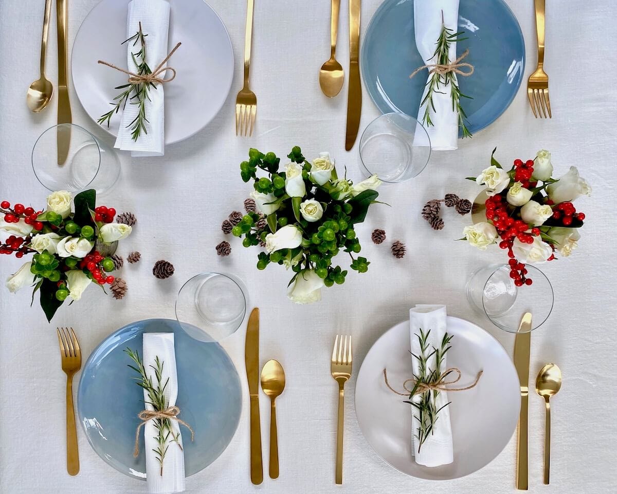 christmas dinner party table set up overhead on white linen