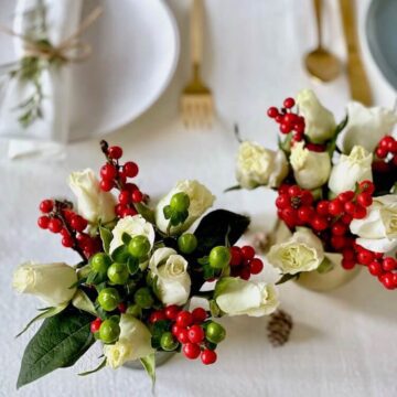 Christmas party ideas feature flowers in votives on white linen
