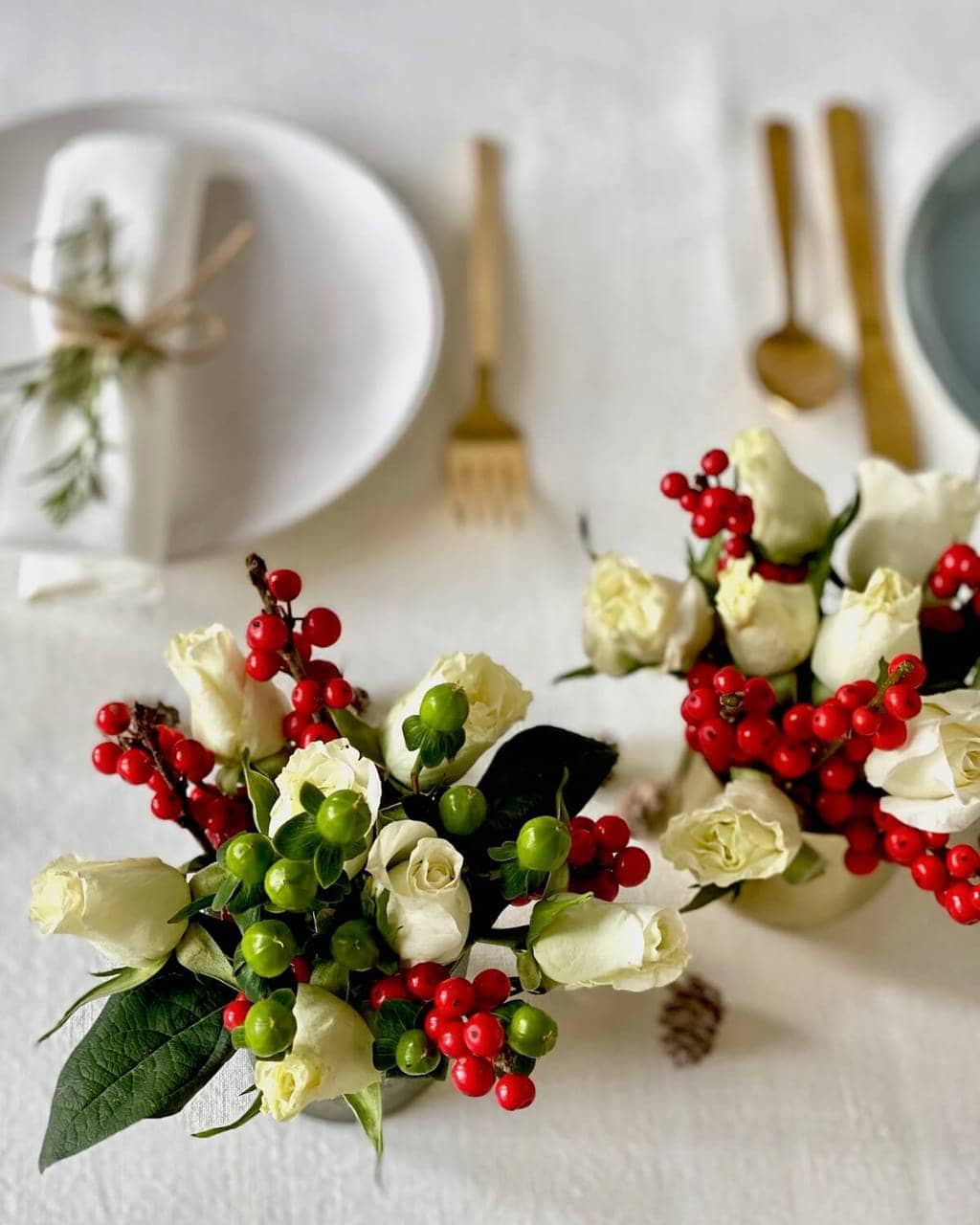 christmas table flower arrangement with roses and red berries