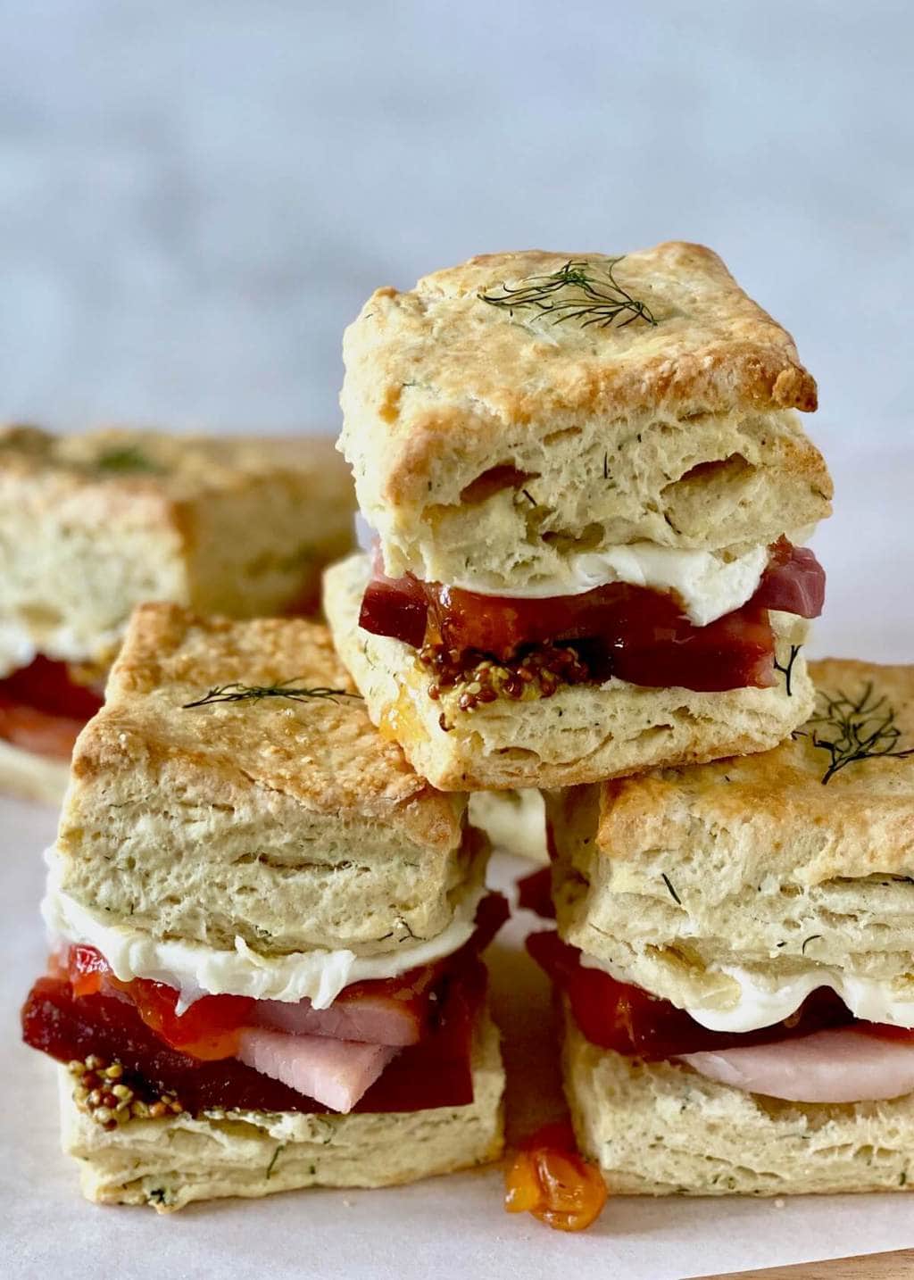 dill biscuits with ham and mustard on parchment