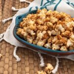 Sweet Chili Spiced Popcorn in blue bowl on brown woven placemat