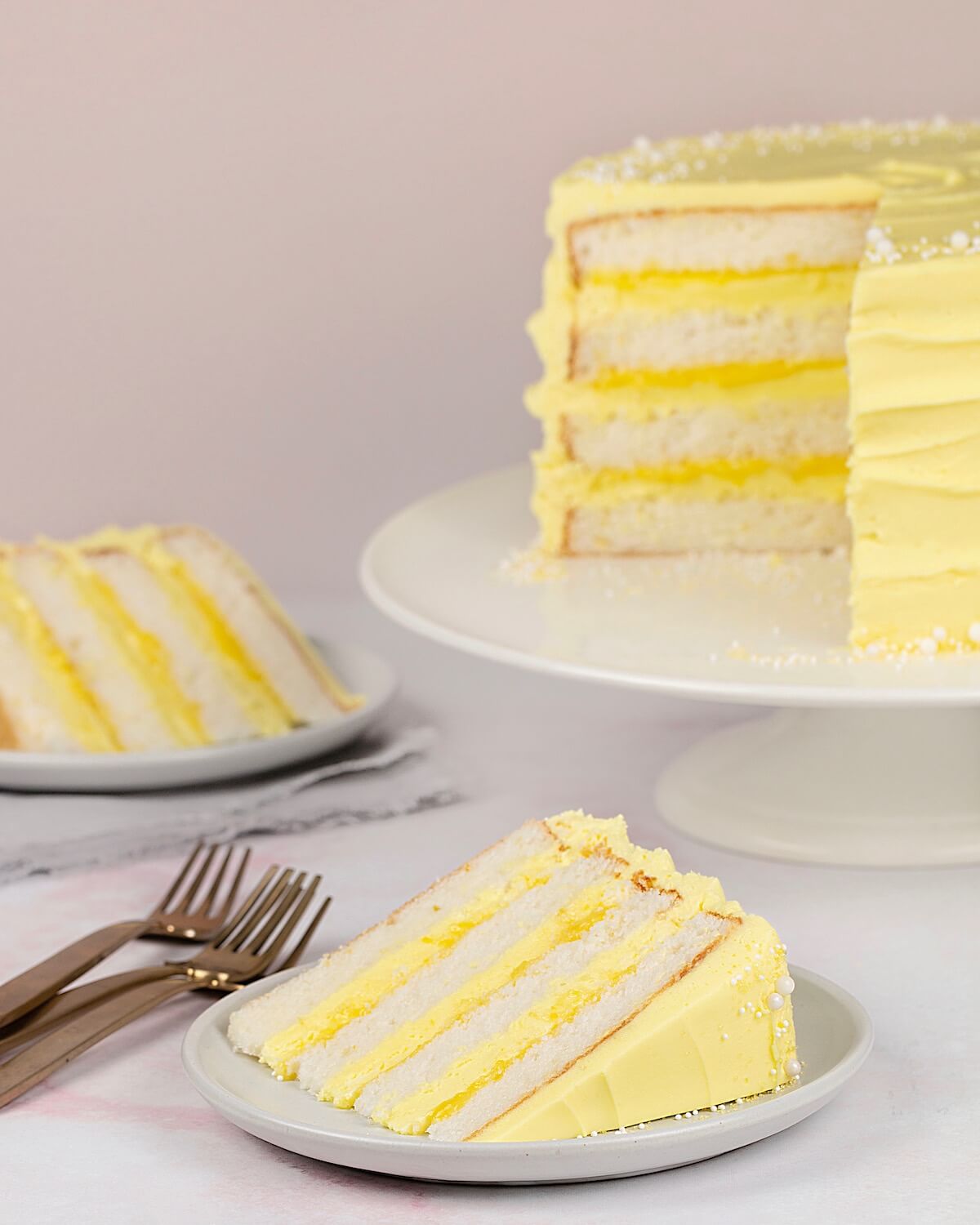 Lemon Cake on cake stand with two slices on plates