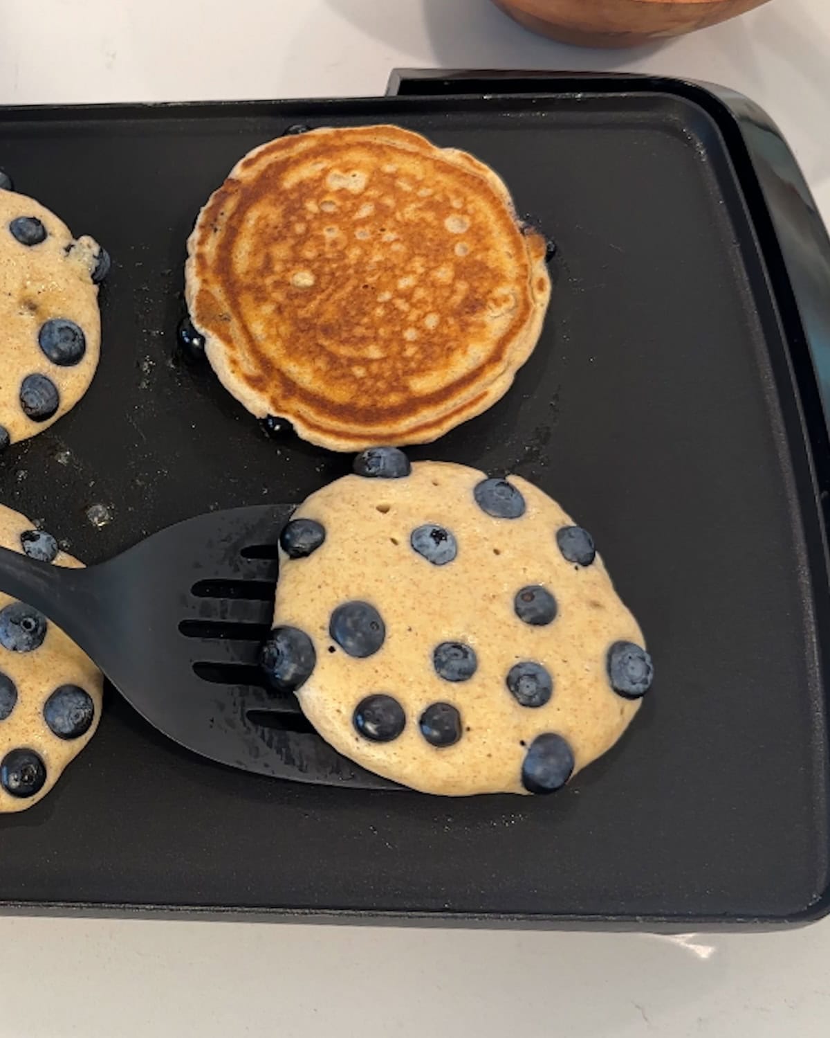 Flipping a pancake over on a griddle.