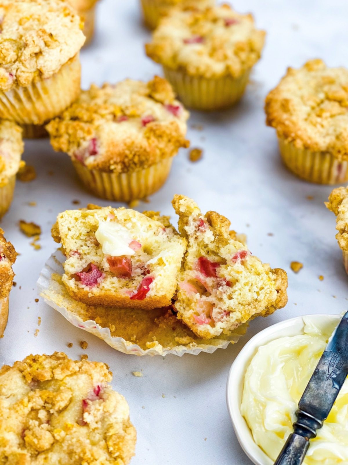 rhubarb orange streusel muffins on marble with butter