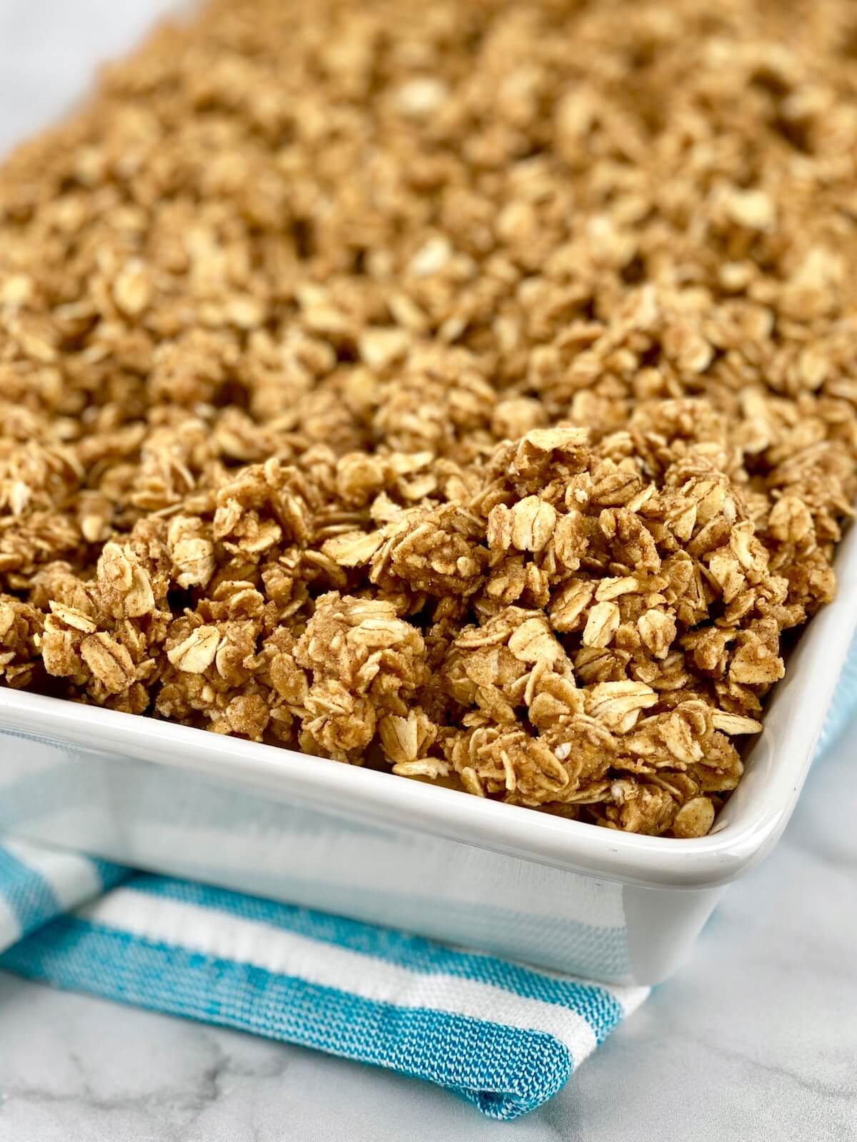 apple crisp with oat topping ready for oven in 9 by 13 pan.