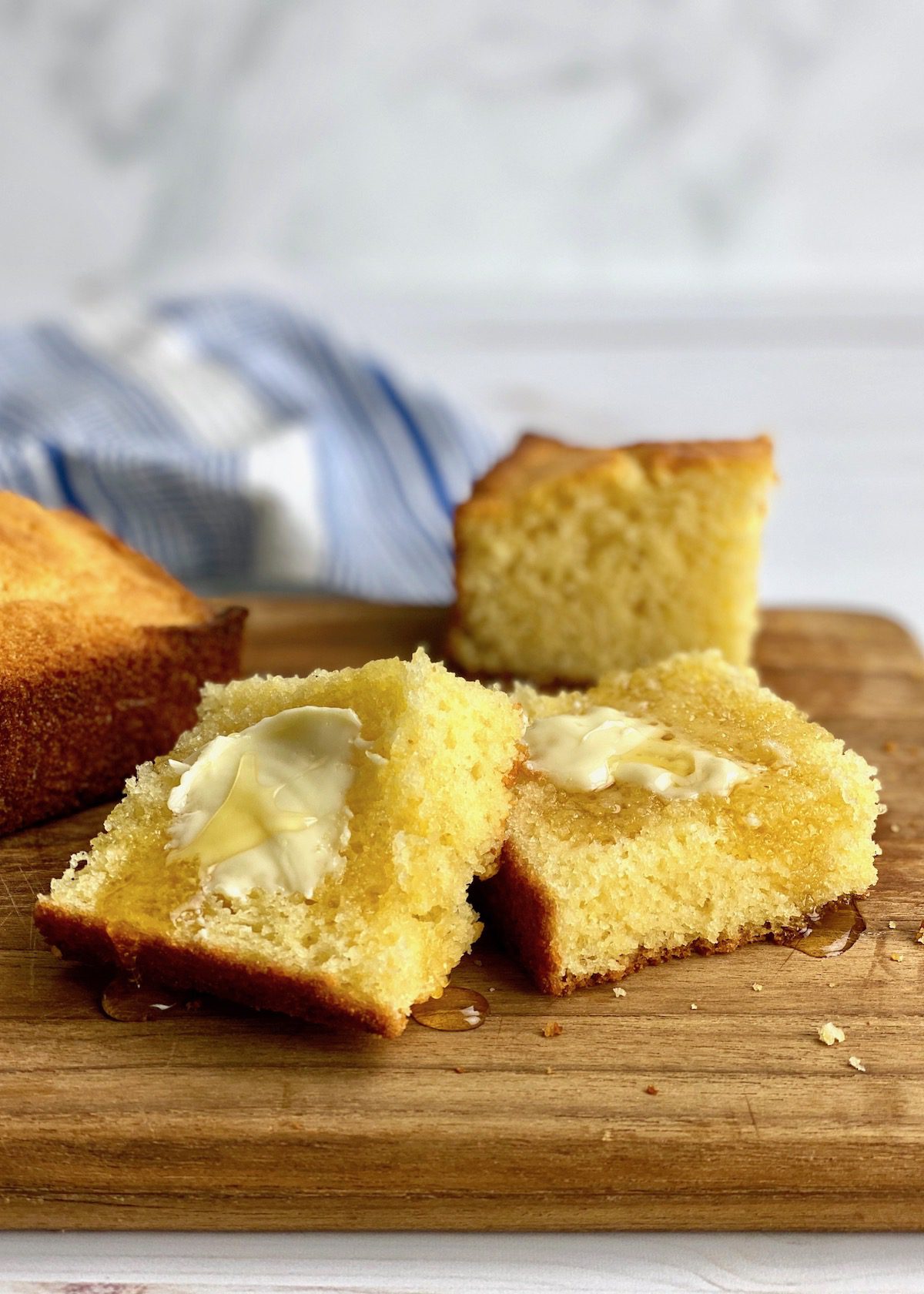 homemade cornbread with butter and honey on a board