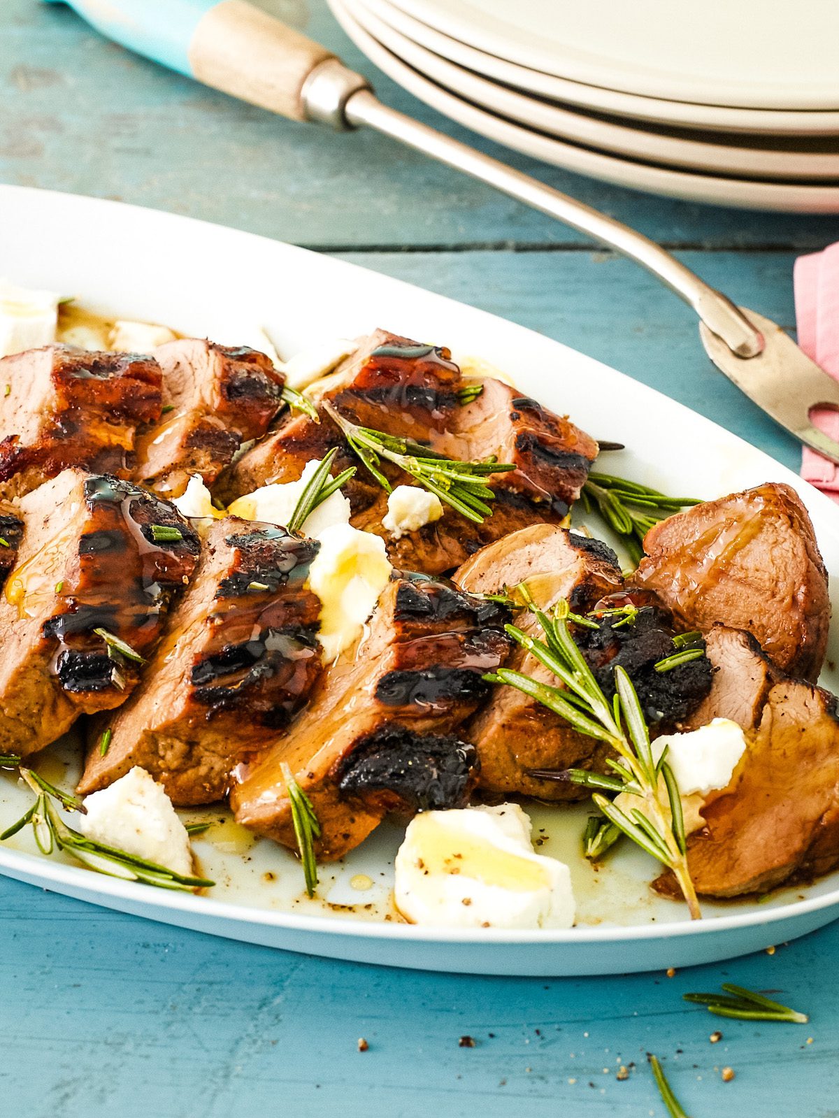 zoomed in view of grilled pork tenderloin sliced on platter