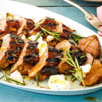 grilled pork on platter with goat cheese and honey