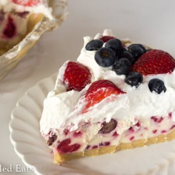 Slice of Berries Cream Ice-Cream Pie on white plate
