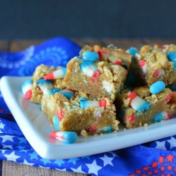 Cookie Bars cut up o na white plate with a patriotic napkin underneath.