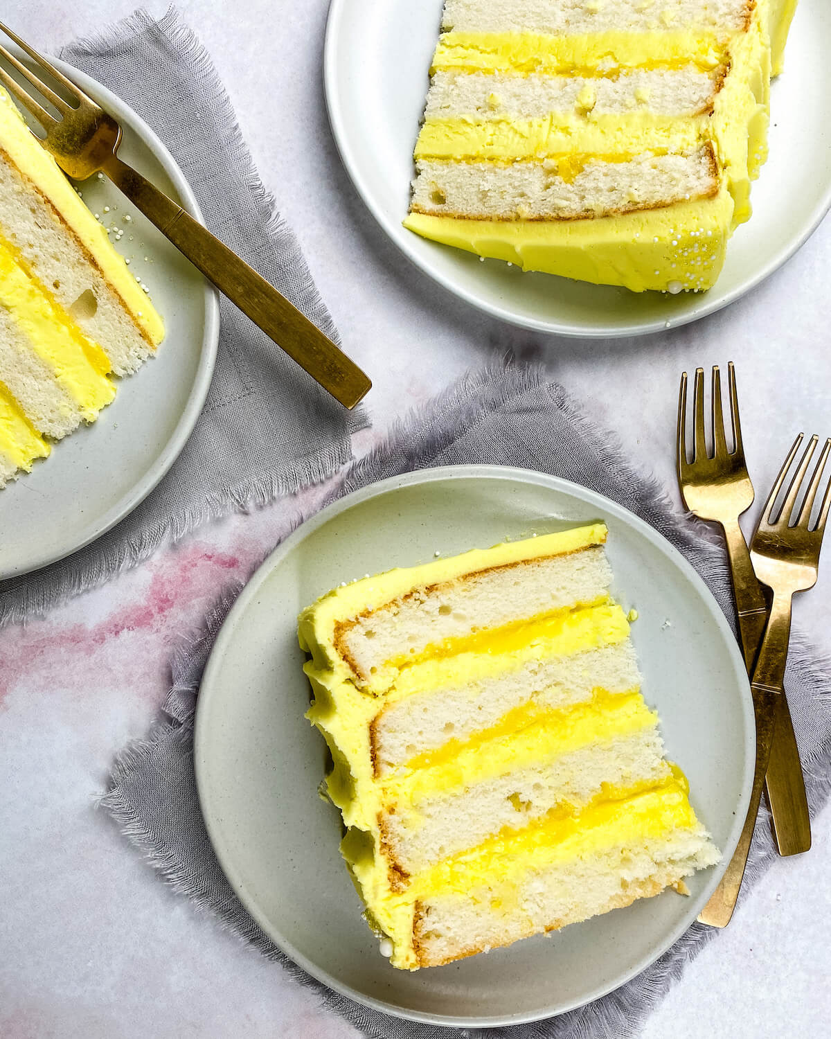 white cake with lemon curd and frosting sliced on plates