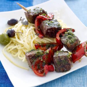 pepper beef kabobs with pasta on plate feature image