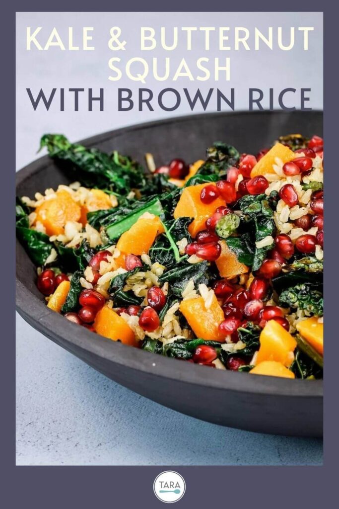 kale and squash salad with brown rice and pomegranates in a slate bowl pin