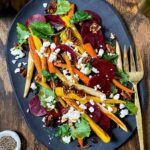 kale and beets with roasted carrots and goat cheese on a black platter