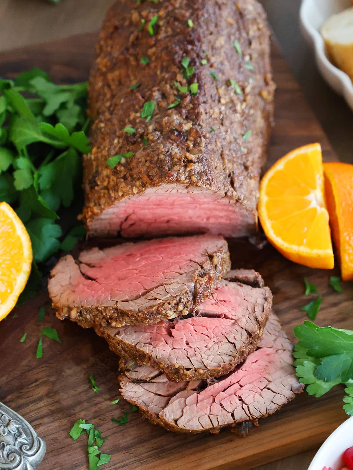 Top view of cooked beef tenderloin with several slices cut off the end. 