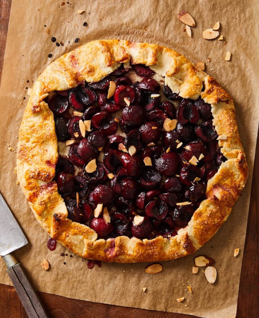 cherry crostata with almonds on brown parchment