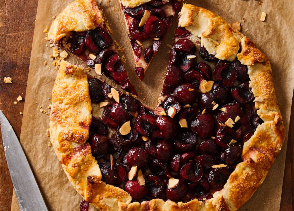 rustic cherry pie with almonds on cutting board