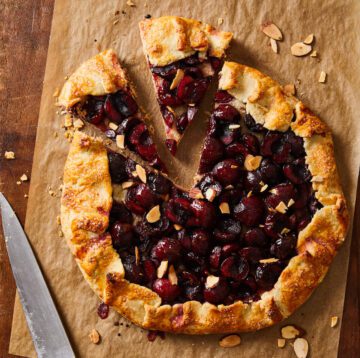 cherry galette on brown parchment with slice out