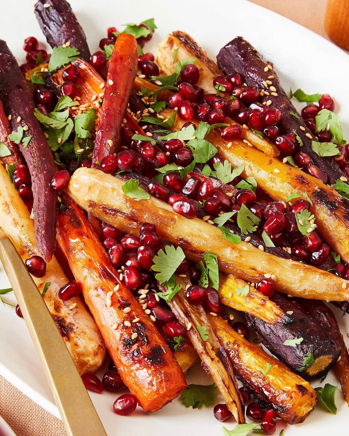 close up of roasted carrots with miso and pomegranate arils