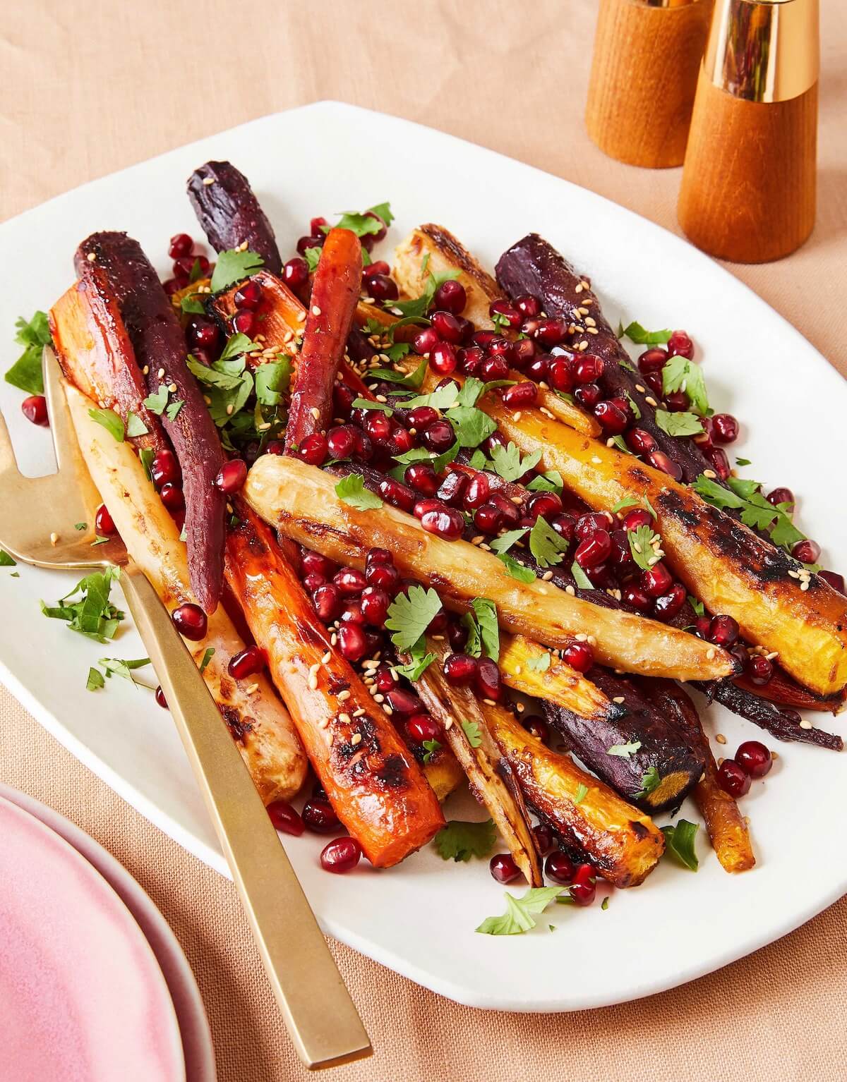 miso roasted carrots with pomegranates on white platter