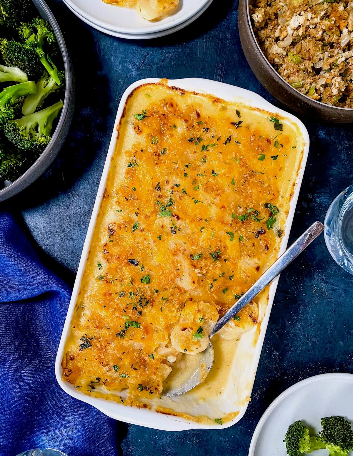 potato casserole in white dish on Thanksgiving table