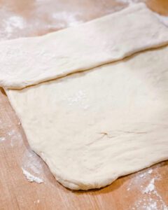folding homemade bread dough into loaf