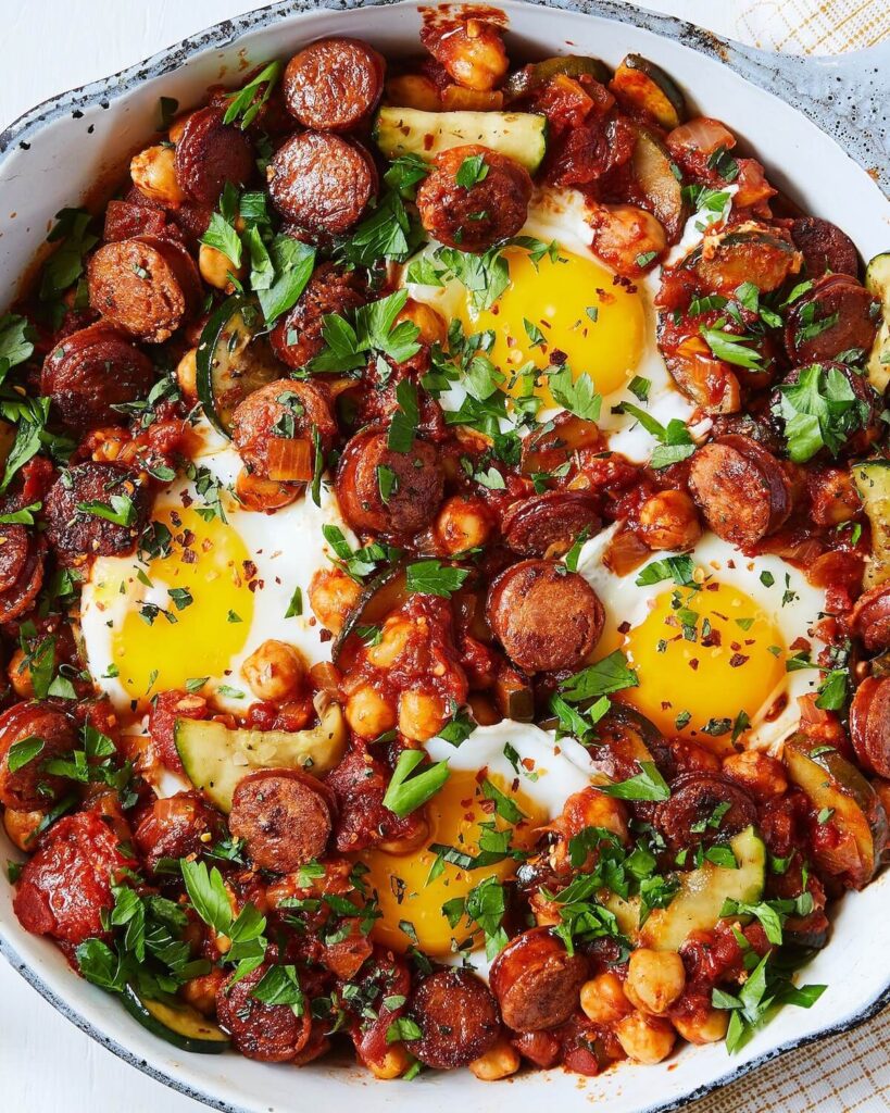 poached eggs with spicy sausage and chickpeas in skillet