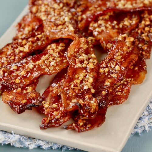 shiny candy maple bacon with nuts on a platter