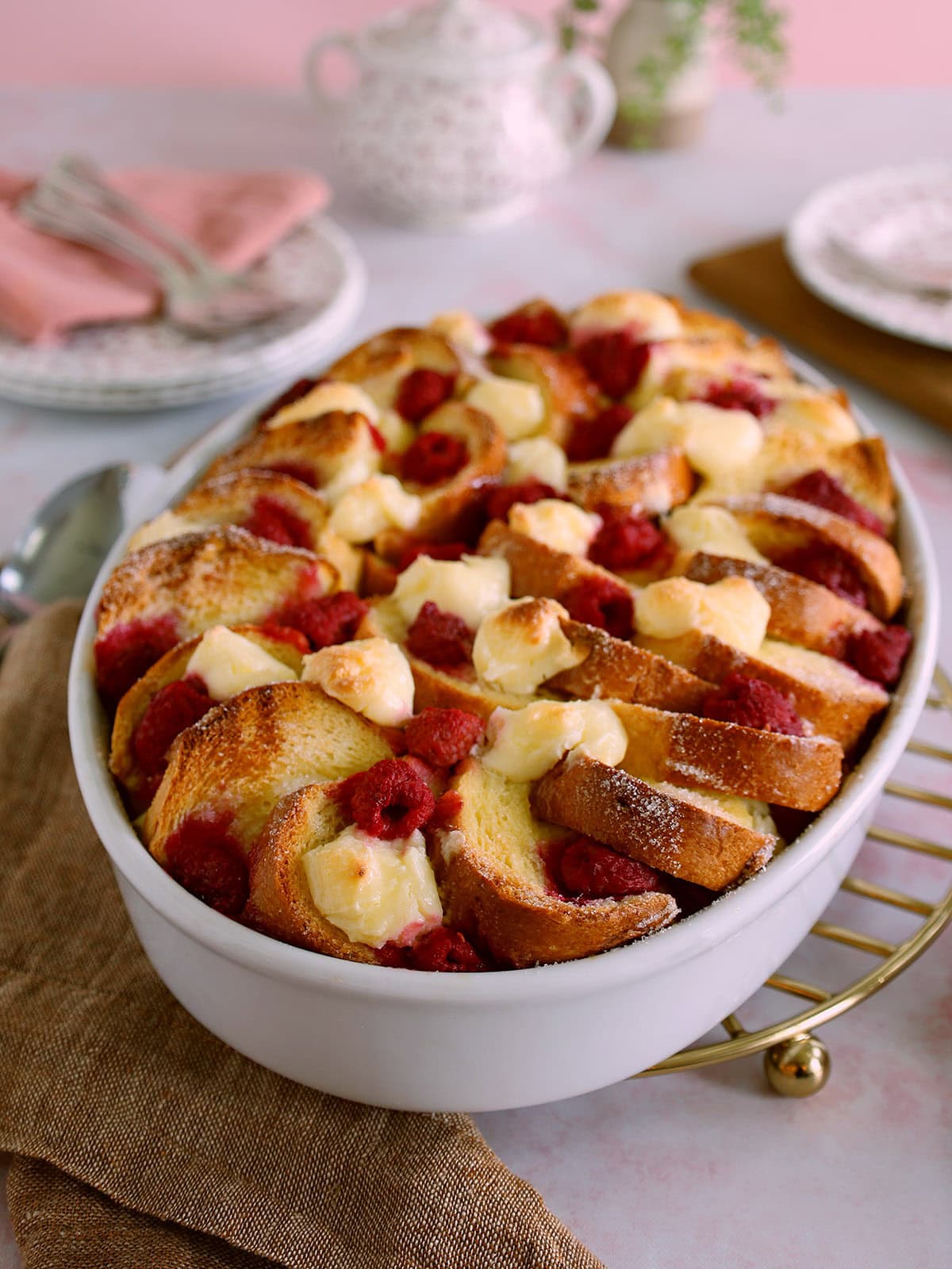A raspberry French toast casserole in an oval baking dish.
