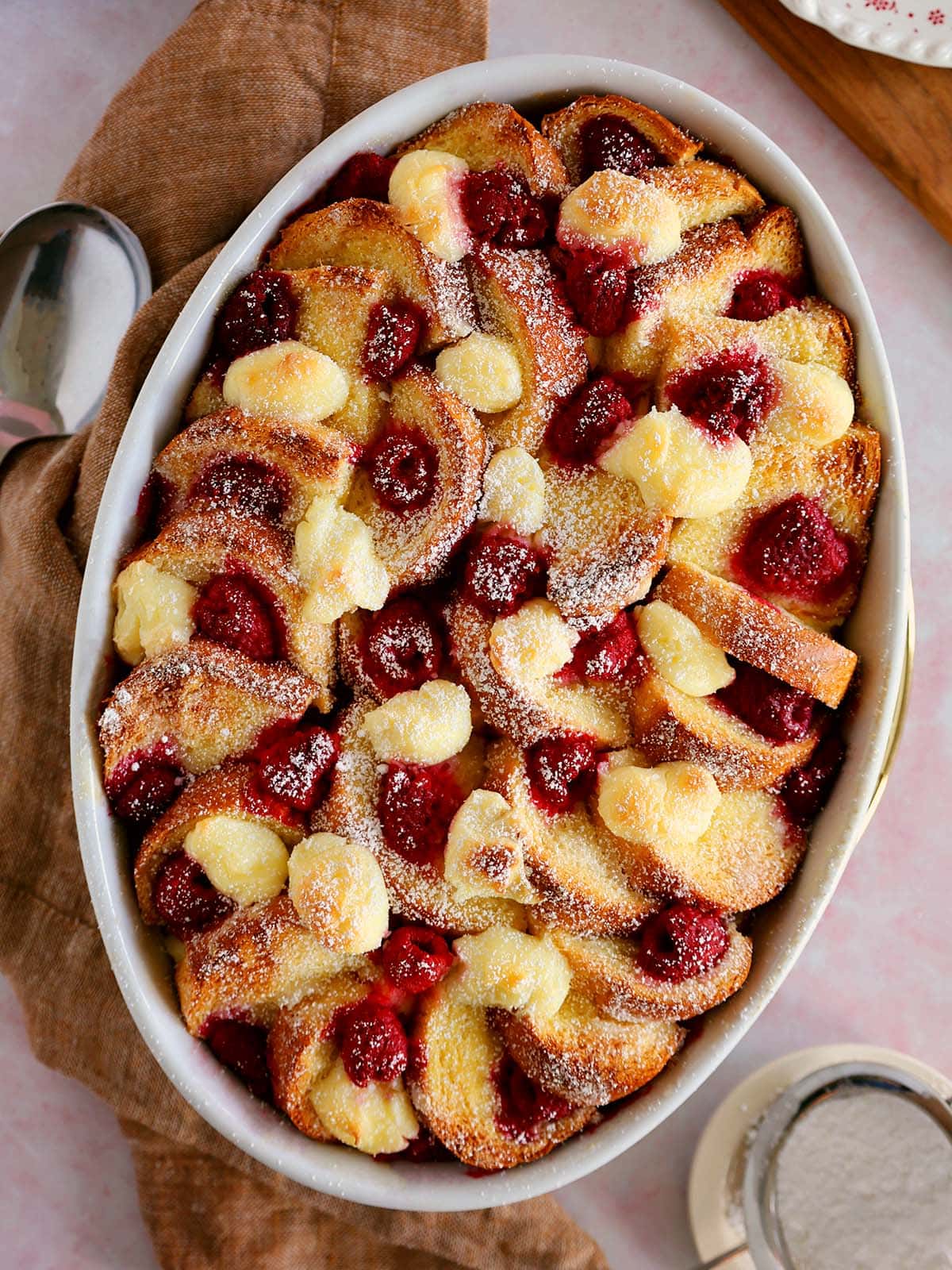 Raspberry bread pudding French toast in an oval baking dish.