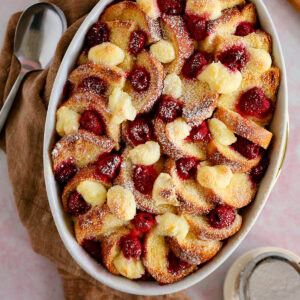 A raspberry bread pudding in a white casserole dish.