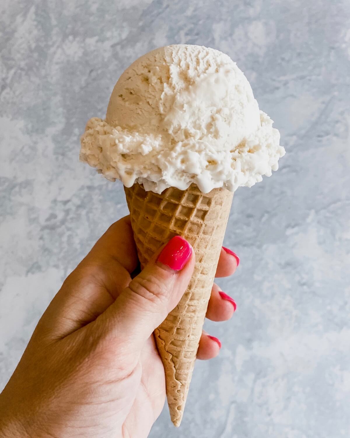 hand holding vanilla ice cream cone