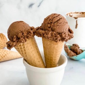 chocolate ice cream scoops in cones with container