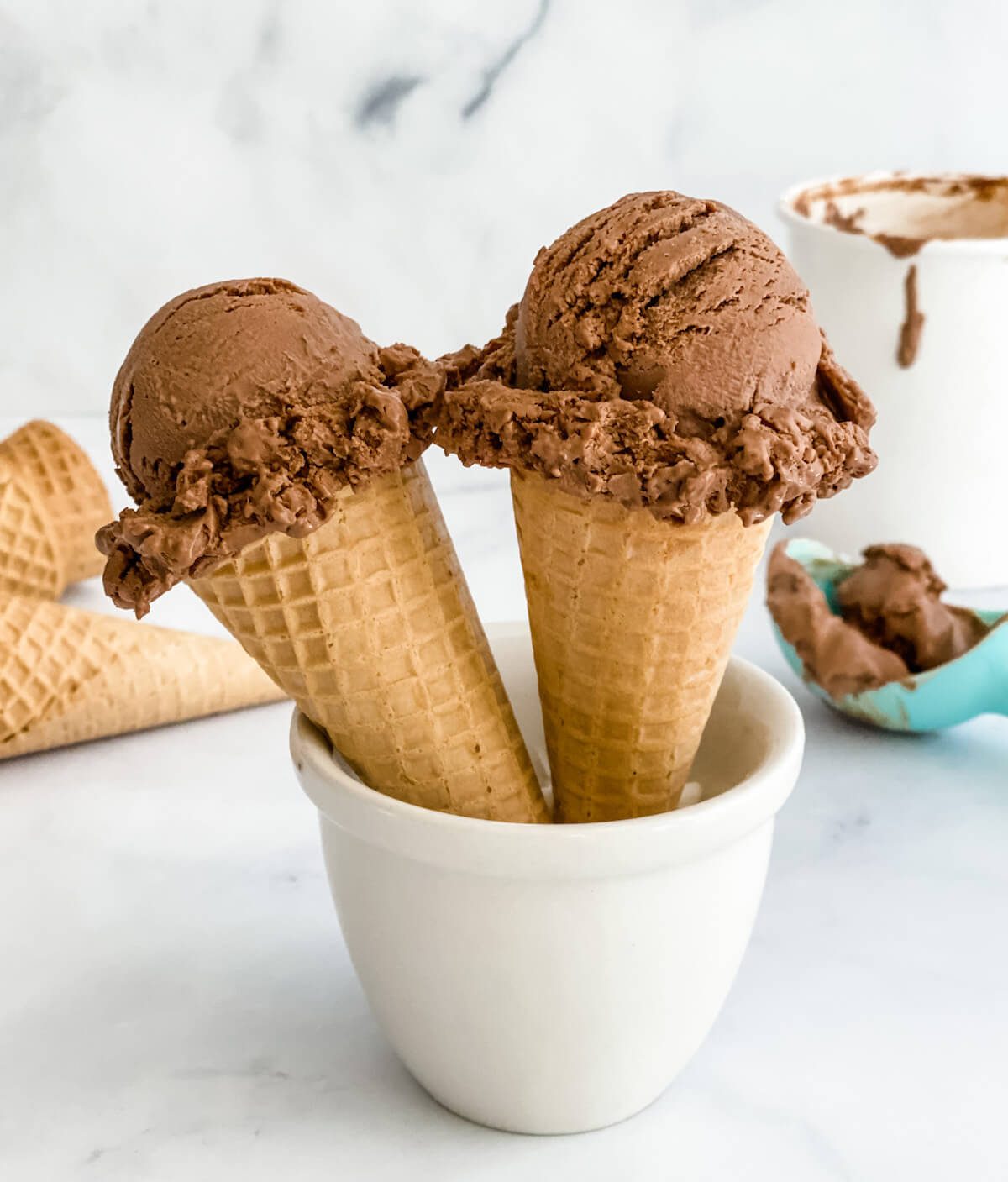 two chocolate ice cream cones in a cup