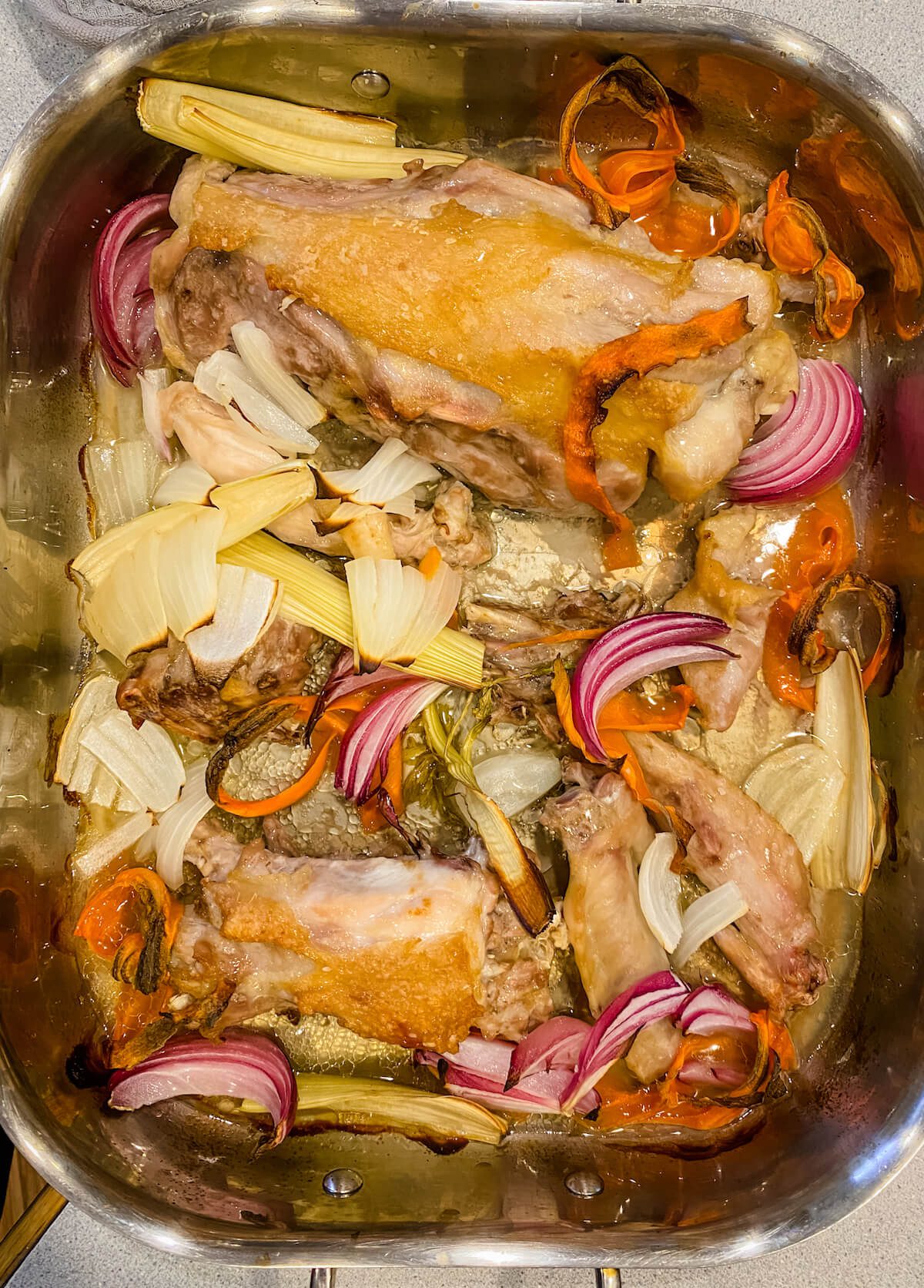 roast turkey parts with vegetables in pan for broth