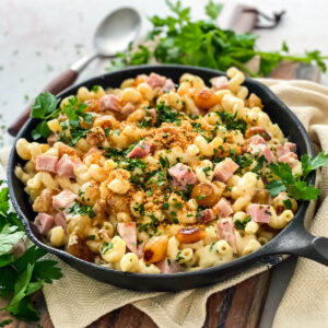ham and pearl onions with mac and cheese is cast iron skillet